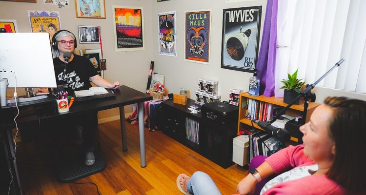 Dani Cutler recording in her studio surrounded by concert posters